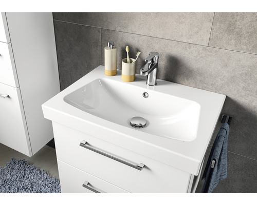 Meuble sous-lavabo avec lavabo, robinet, distributeur de savon et gobelet à brosses à dents dans la salle de bain