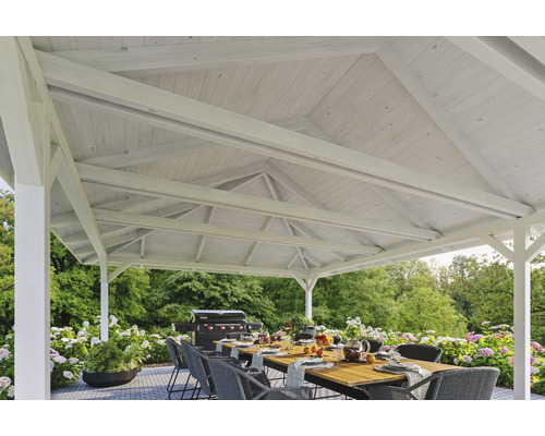 Coin salon de jardin couvert avec table, chaises et barbecue