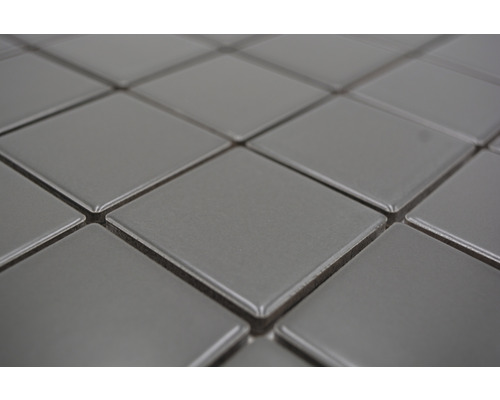 Detailaufnahme von quadratischen, grauen Keramikfliesen.