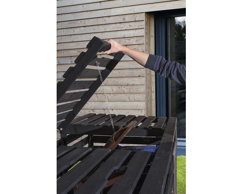 Offener Mülltonnenbox-Deckel mit Hand im Außenbereich.