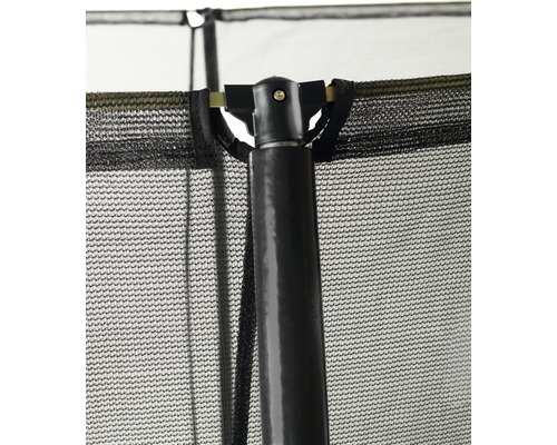 Gros plan d''un filet de sécurité de trampoline avec une structure en maille noire et un poteau de support foncé et robuste.
