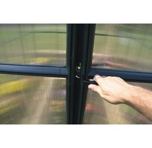 Detailansicht eines Gewächshauses mit Hand am Türgriff