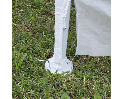 Vue détaillée du pied d''une tente de réception avec des piquets dans l''herbe