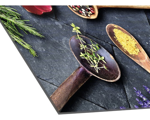 Dekoratives Küchenbild mit Kräutern und Gewürzen in Holzlöffeln auf Schieferplatte