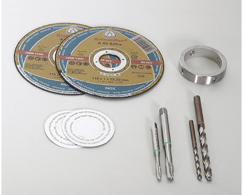 Zwei Trennscheiben, ein Metallring, zwei Gewindebohrer und zwei Spiralbohrer liegen auf einer hellen Oberfläche.
