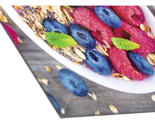 Gros plan d''un bol de muesli, framboises, myrtilles et menthe sur une table en bois