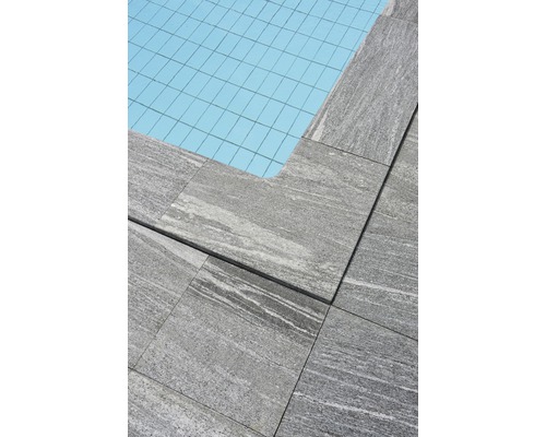 Vue détaillée de dalles de terrasse grises au bord d''une piscine