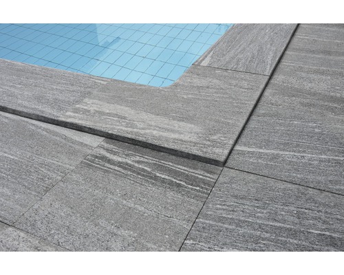 Vue détaillée de margelles de piscine en pierre autour d''une piscine