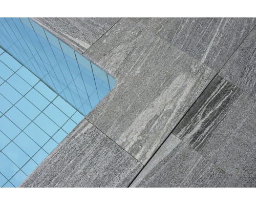 Gros plan de plaques de pierre grises à côté d''une façade en verre