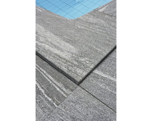 Gros plan de dalles de pierre grises autour d''une piscine