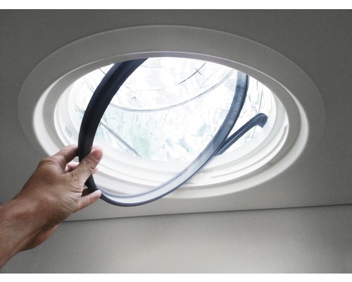 Vitre supplémentaire VELUX ZTB 0K14 2002 pour conduit de lumière Une personne installe un joint dans une fenêtre de toit ronde.