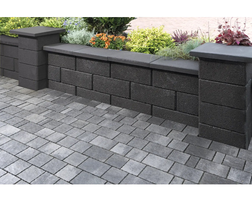 Gartenmauer aus Betonsteinen mit Bepflanzung und Pflastersteinen