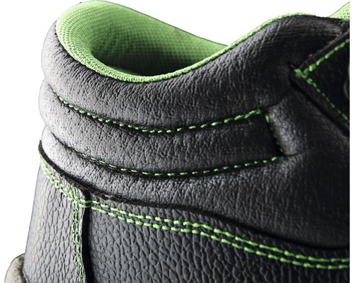 Gros plan sur une chaussure de sécurité noire avec des coutures vertes