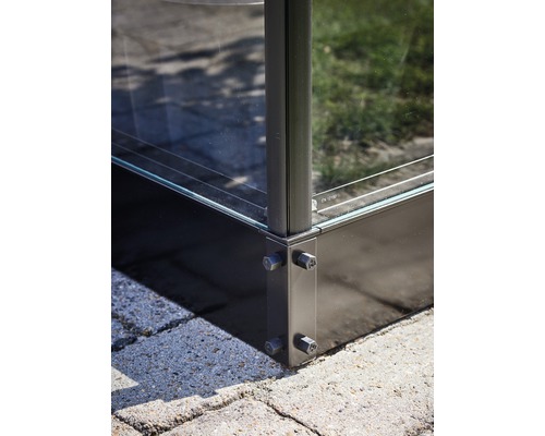 Vue détaillée d''une construction en verre avec raccord d''angle métallique et vissage.