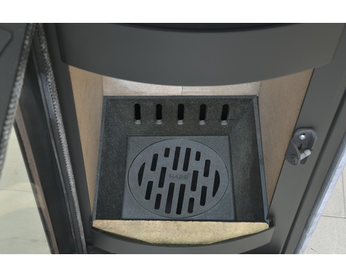 Innenansicht eines Kaminofens mit Rost und Feuerraumauskleidung