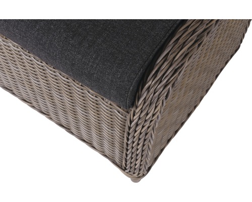 Detailansicht eines Korbsessels mit grauem Kissen.