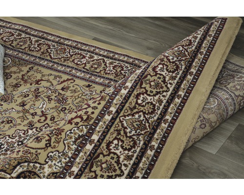 Tapis à motif floral, partiellement enroulé.