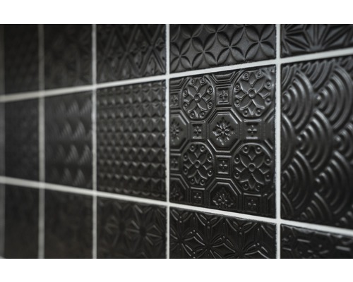 Gros plan de carreaux noirs avec différents motifs