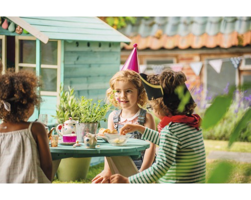 Enfants jouant dans le jardin avec cabane et table de pique-nique
