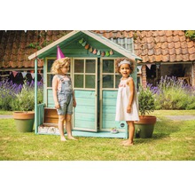 Maisonnette avec deux enfants dans le jardin. Décoration avec guirlande et chapeaux de fête.