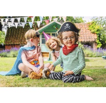 Trois enfants en costumes sont assis avec un cochon d''Inde dans le jardin.
