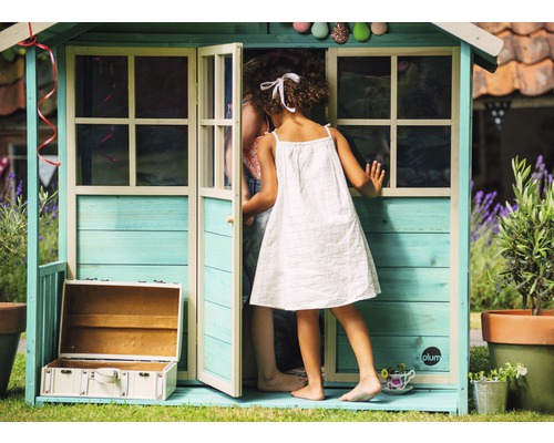 Scène avec un enfant entrant dans une cabane en bois installée dans le jardin
