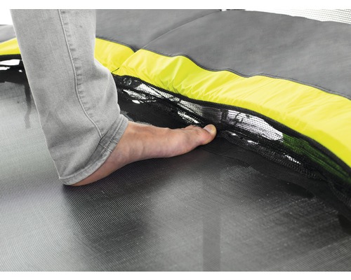 Detailaufnahme eines Trampolins mit Fuß auf der Sprungfläche