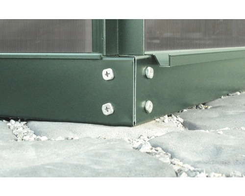 Detailansicht einer Gewächshaus-Ecke mit Schrauben auf Steinboden