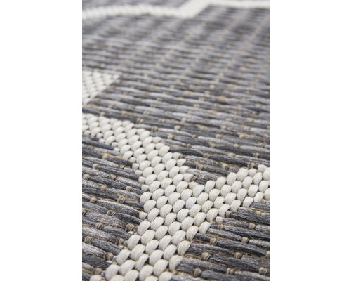 Detailansicht eines grau-weißen Teppichs mit geometrischem Muster