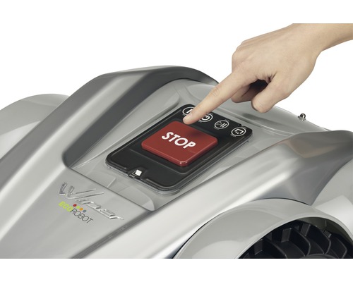 Un doigt appuie sur le bouton stop d''un robot tondeuse à gazon.