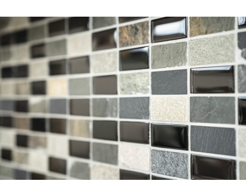 Mur de carreaux de mosaïque avec des carreaux rectangulaires dans différentes nuances de gris et textures