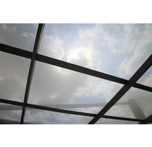 Vue d''une construction de toit en verre avec le ciel et les nuages en arrière-plan.