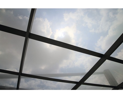 Vue d''une construction de toit en verre avec le ciel et les nuages en arrière-plan.