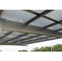 Gros plan d''un carport avec toit en verre et cadre en métal.