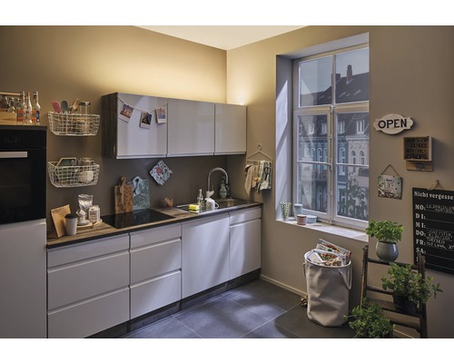 Cuisine lumineuse avec placards intégrés, évier, fenêtre et éléments décoratifs