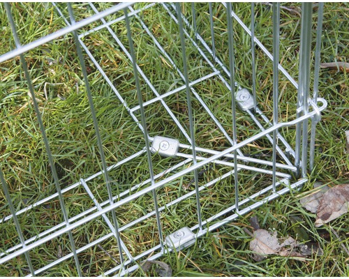 Vue détaillée d''une cage grillagée métallique sur l''herbe