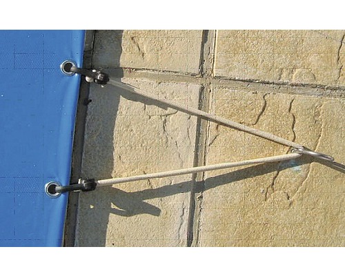 Gros plan d''une couverture de piscine avec câble de fixation sur le bord de la piscine