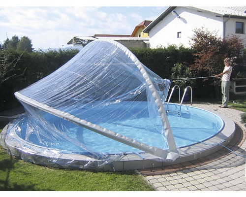 Piscine ronde avec toit de piscine transparent dans le jardin.