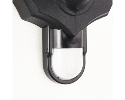 Gros plan d''un luminaire extérieur noir avec détecteur de mouvement.
