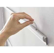 Anbringen einer Zierleiste mit Klebeband an der Wand
