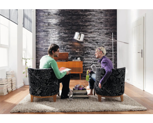 Salon avec deux personnes assises dans des fauteuils, lampadaire et décoration sur un tapis