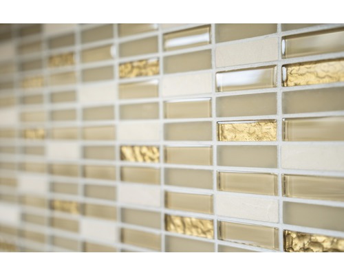 Nahaufnahme einer Wand mit Mosaikfliesen in Beige-, Gold- und Creme-Tönen