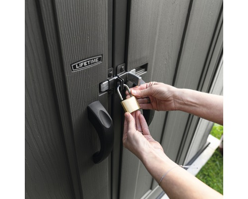 Personne fermant un abri de jardin avec un cadenas