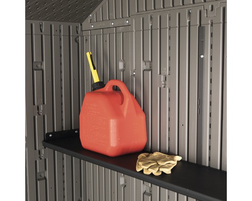 Vue intérieure d''un abri de jardin avec étagère, jerrican d''essence et gants de travail