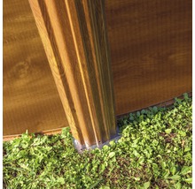 Vue détaillée d''une construction de cabane de jardin avec poteaux et éléments muraux à l''extérieur.