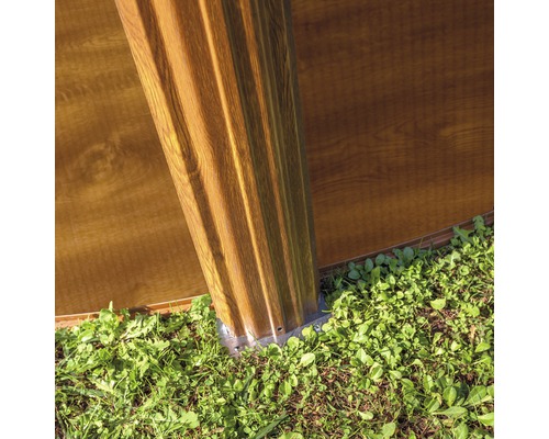 Vue détaillée d''une construction de cabane de jardin avec poteaux et éléments muraux à l''extérieur.