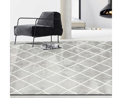 Grauer Teppich mit Rautenmuster in einem Wohnzimmer mit Sessel und Kamin.