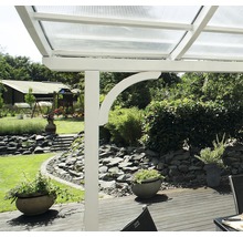Detailansicht einer Terrassenüberdachung mit weißem Rahmen und durchsichtigem Dach in einem Garten.