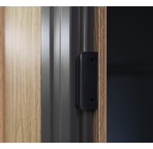 Vue détaillée d''un ferme-porte noir sur une porte en bois