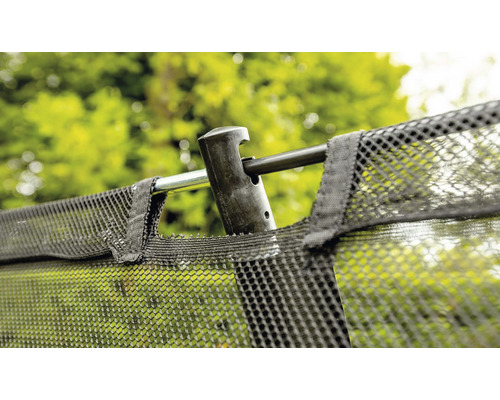Gros plan sur le filet de sécurité d''un trampoline de jardin avec barre de cadre